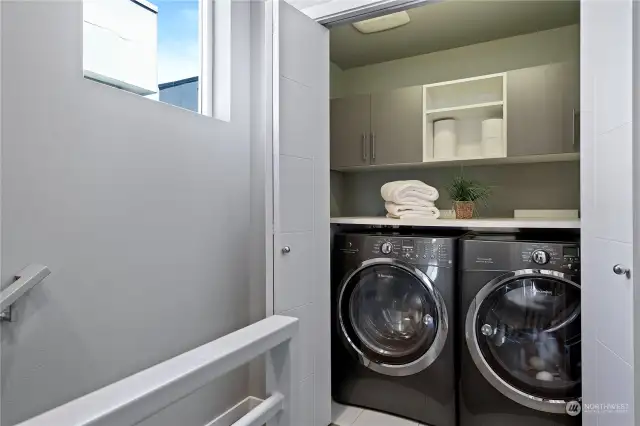 The laundry with full size washer and dryer is located on the top landing near the primary bedroom.
