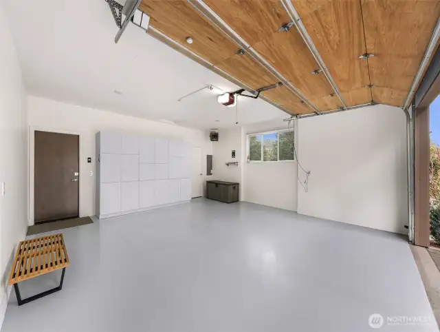 2 car garage with epoxied floor, new storage cabinets, EV charging ready and an electric ceiling mounted heater.