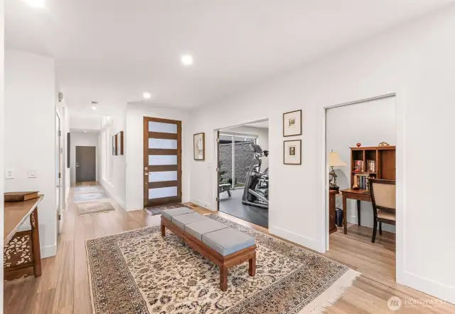 The large welcoming foyer connects to the home gym, small bonus room and the hallway to the guest room, laundry room and garage.