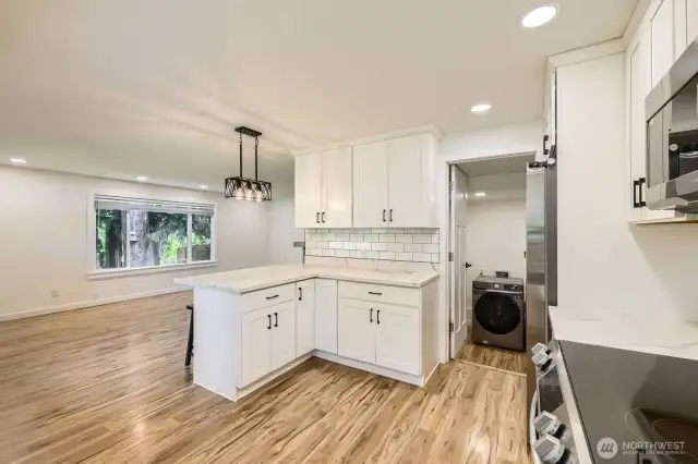 New laminate vinyl flooring with an open floor plan. Separate washer and dryer room just off the kitchen