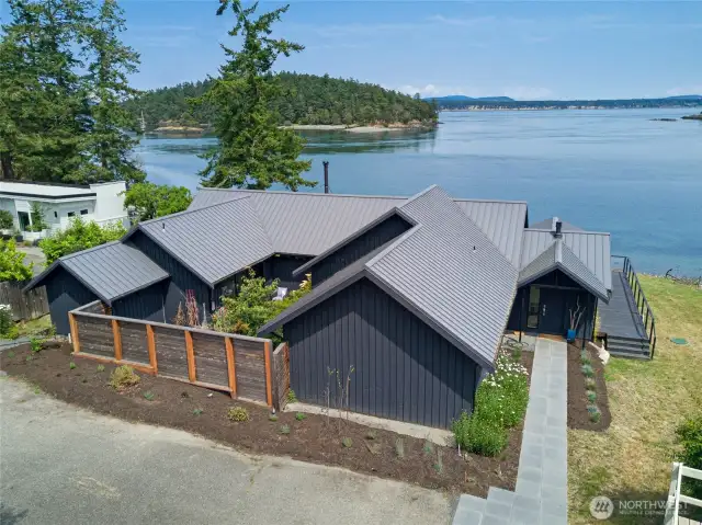 The main house features an inner courtyard and is nestled along the shore.
