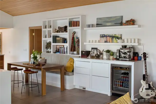 The dining area with built-in shelves and counter and beverage refrigerator.