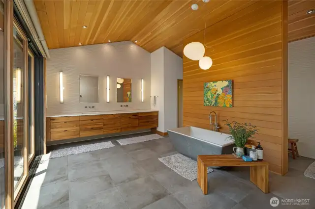 The generous bathroom off the primary bedroom is a calm space with double vanity and a soaking tub, walk-through shower and separate toilet room. Sliding doors open up to the peaceful inner courtyard.