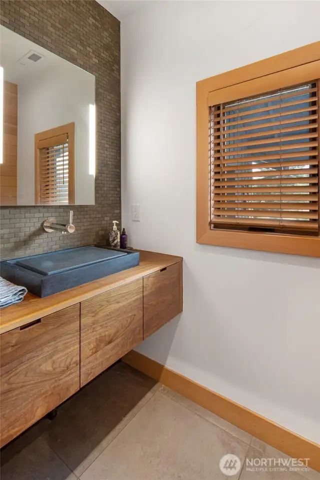 The powder room in the hallway with a sleek modern feel.