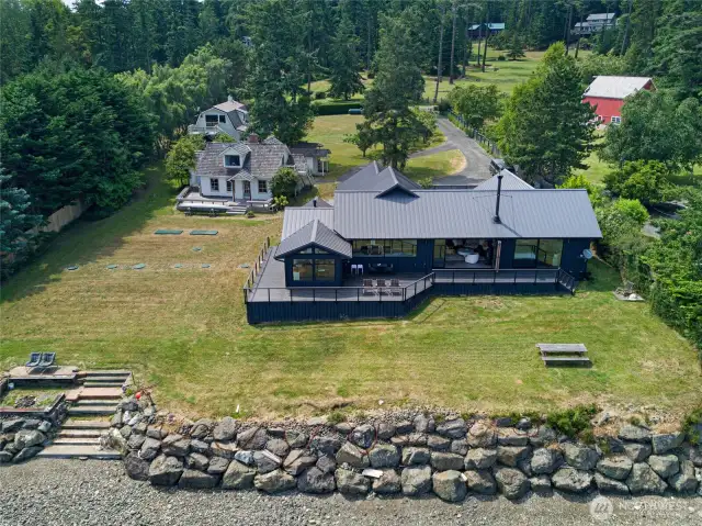 The main house in the front, the 1930 farm house on the left and the barn-style shop with apartment behind the farm house. Steps lead down the bulkhead onto the 150ft of private beach.