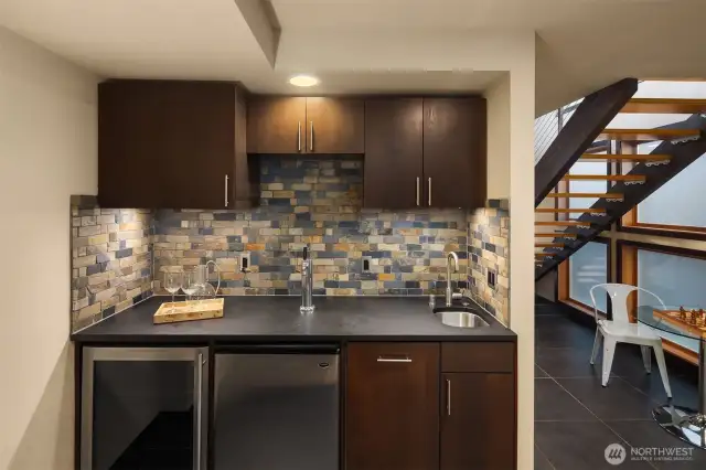 Private bar area with Kegerator, wine refrigerator, dishwasher, undermount stainless steel sink and custom cabinets