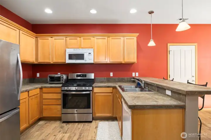 Another view of the kitchen with the shaker-style cabinets and the tile countertops.