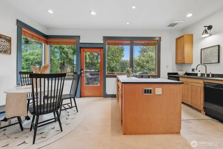 Love this kitchen! Wrapped in greenery and with great flow to the deck and backyard. Full bath to the right.