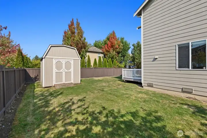 Another view of deck, shed and large side yard in the fully fenced in back yard.
