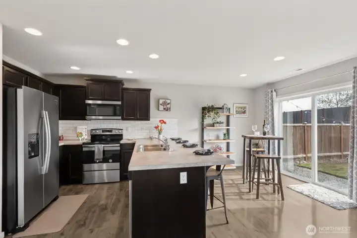 Dining Area  -  SS Appliances, Breakfast Bar, Slider to Patio & Backyard