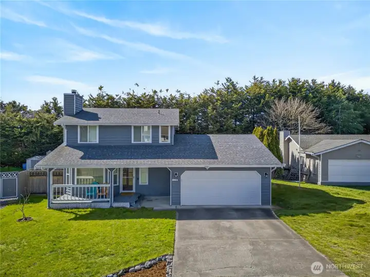 Inviting two-story home with a covered front porch, spacious yard, and attached two-car garage, offering comfort and everyday livability in a quiet setting.