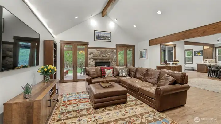 Grandeur Living Room for Your Enjoyment with Tall Ceilings, Fireplace, and French Doors leading out to Covered Patio