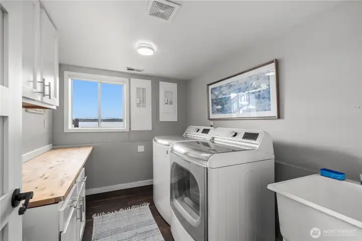 Functional laundry room featuring abundant storage, folding space, and utility sink for added convenience. Functional laundry room featuring abundant storage, folding space, and utility sink for added convenience.