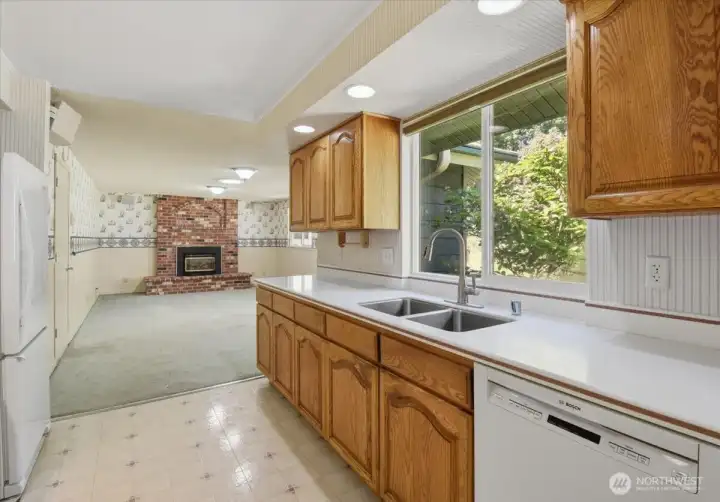 Galley Kitchen with solid surface counters and oak cabinets.