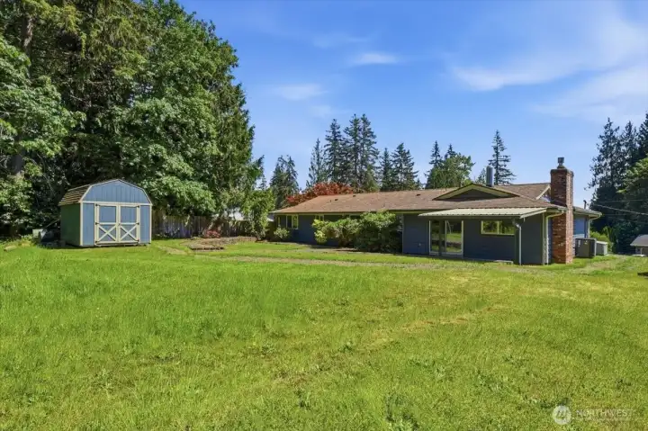 Back of home with level upper yard and large outbuilding/shed.