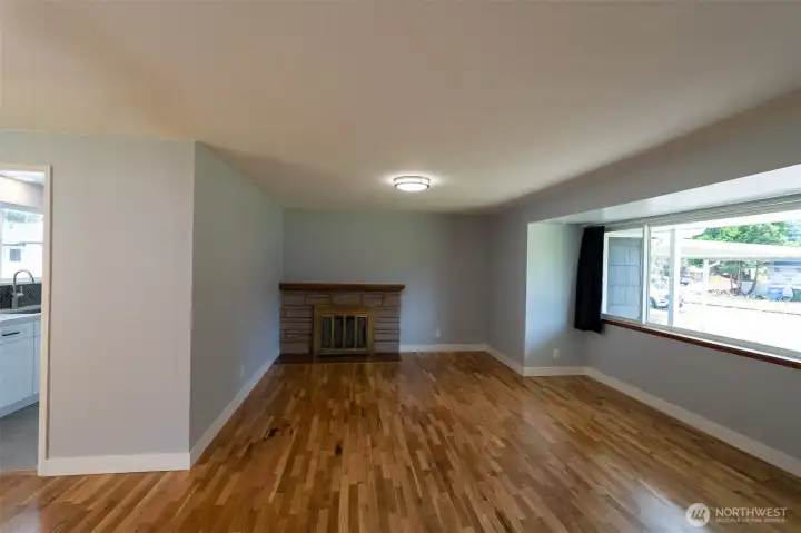 View of your family room showing the amazing natural wood fireplace, hard to find these days! Kitchen to your left.