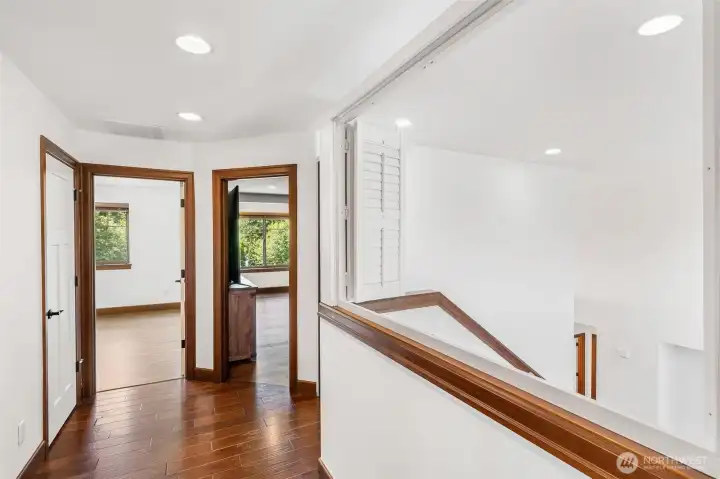 Upstairs hallway with shutters at railing Upstairs hallway with shutters at railing