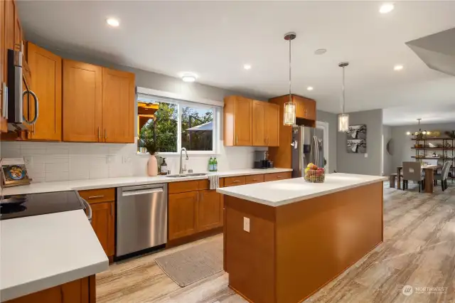 Solid core wood cabinets in the kitchen with stone countertops. Timeless subway tile back splash, sconce lighting and thoughtfully positioned kitchen sink overlooking your private backyard oasis.