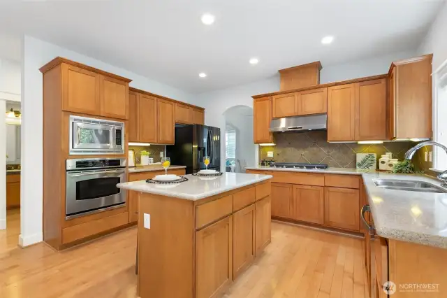 Gourmet kitchen with quartz countertops, center island, undercabinet lighting, and BRAND NEW Samsung gas cooktop & vent hood.