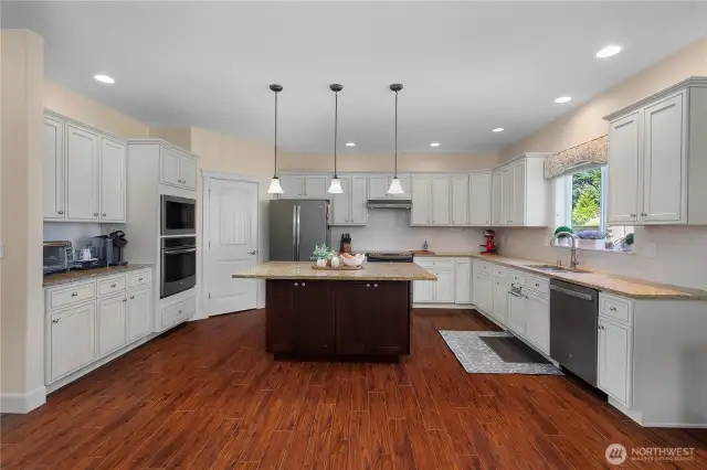 Beautiful Chef's kitchen with granite counters and subway tile backsplash, breakfast island, stainless steel appliances, and walk-in pantry.