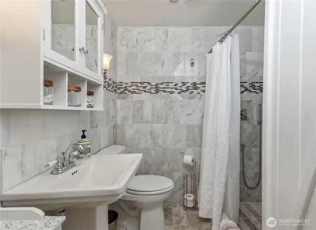 ADU bath with marble tile walls and shower
