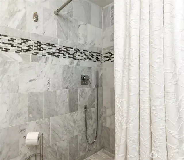 ADU bath with marble tile walls and shower