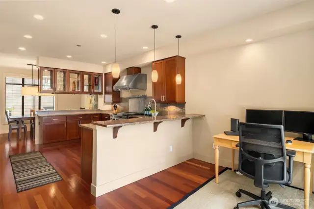 Currently used as a home office, with a perfect view out the front window, this space could easily hold a kitchen table and bar stools for the counter.