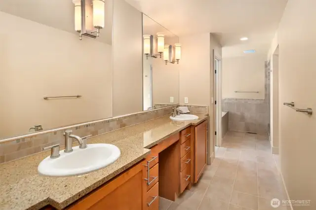 Dual sinks and plenty of counter room, leads to the shower and soaking tub.