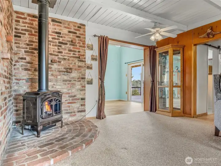 A propane stove in the entry/family room. From here you can go into the kitchen or off to the left is a dining room with access to the backyard.
