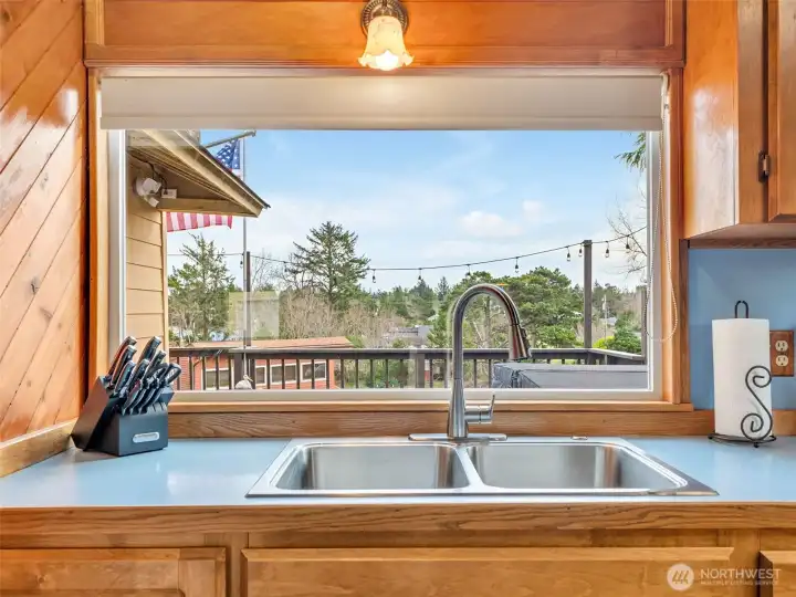 Large window over the sink overlooking the back porch.