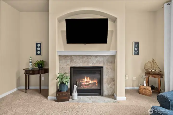 Elegant gas fireplace with art/TV alcove above and symmetrical spaces ideal for built-in bookcases creates a beautiful focal point in the inviting living room.