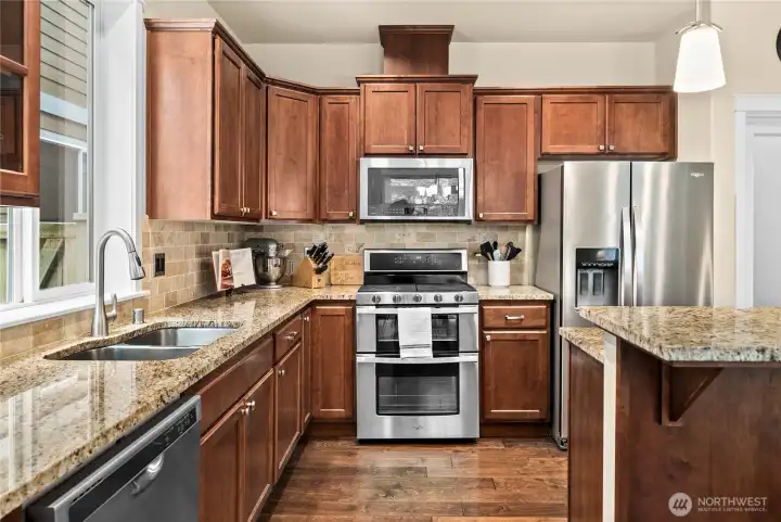 Expansive counter space, full tile backsplash, and abundant cabinetry offer both beauty and functionality.