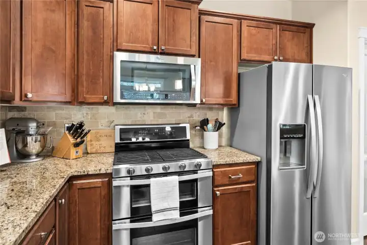 Thoughtfully designed kitchen with stainless steel appliances including a gas range with double ovens, built-in microwave, refrigerator with filtered water and ice and dishwasher.