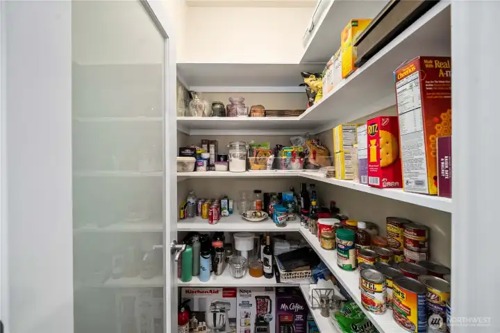 Spacious walk-in pantry with custom shelving provides exceptional storage and organization.