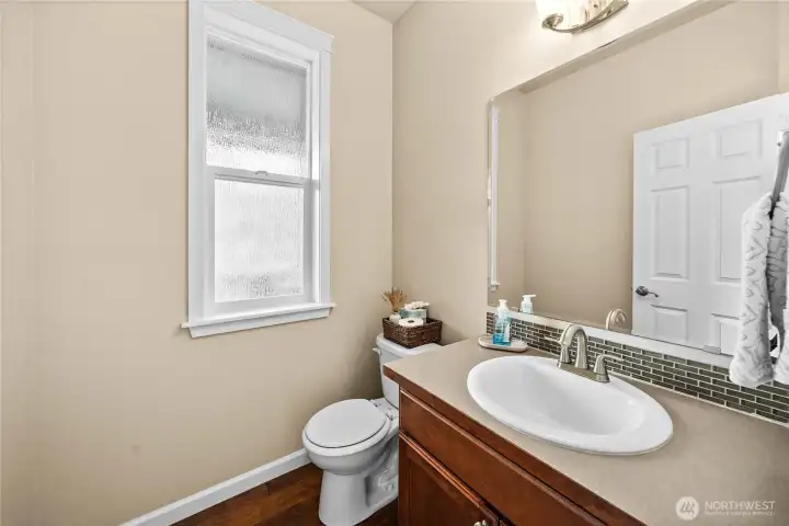 Convenient main-level powder room with stylish vanity and natural light.
