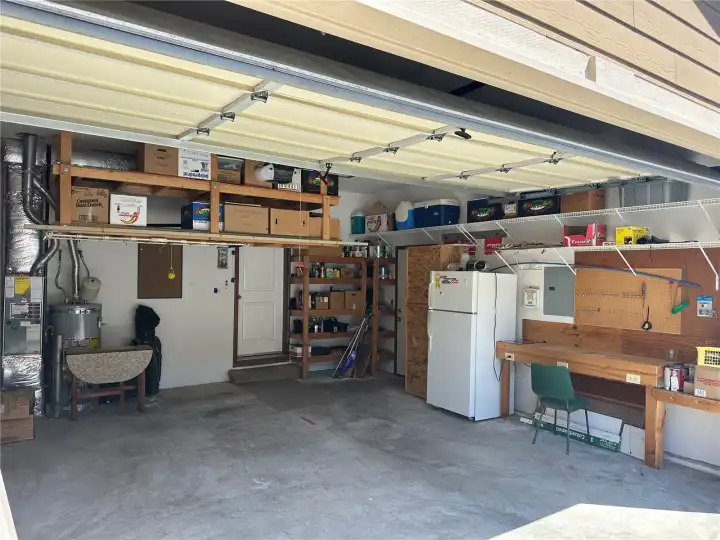 Garage has a work bench and tool hanging area.