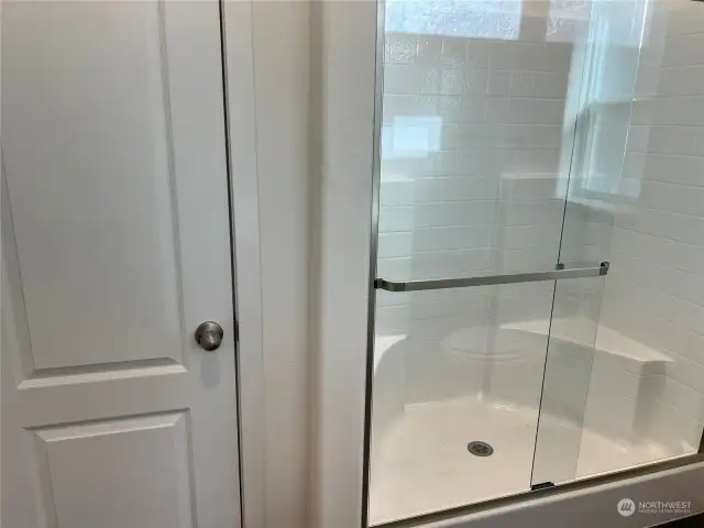 Primary bath walk in shower and linen closet.