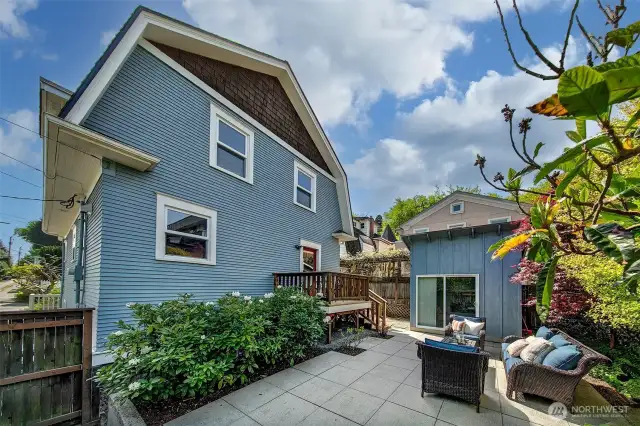 Heading back outside - elevated cedar deck, paver patio all enclosed with a cedar fence and greenery.