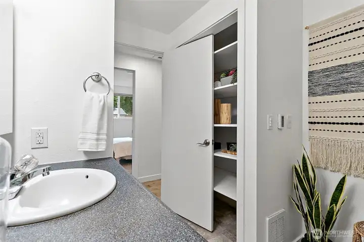 Same bathroom with vanity and convenient closet for extra storage.