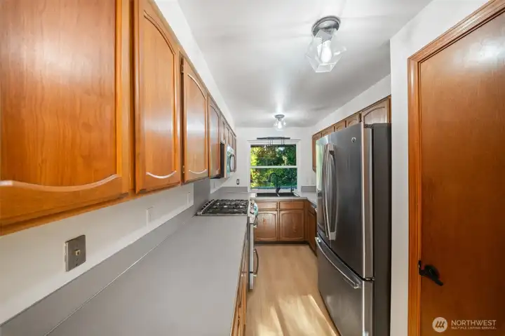 Galley style kitchen offers loads of counter space, newer stainless appliances, all included, and a pantry!