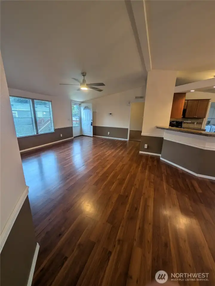 Another angle of the living room with lots of natural light, lovely laminate floors and easy access to the kitchen.