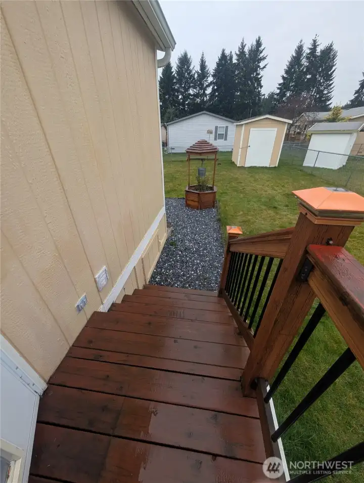 From back door looking over fenced backyard, garden shed, gravel area, etc.