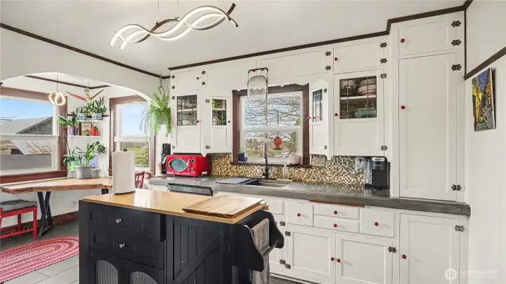 Unique and charming kitchen with wooden cabinetry and continued archways.