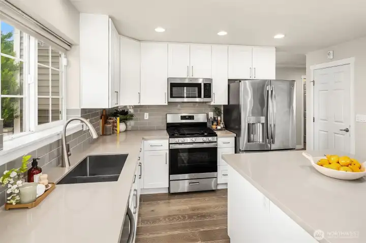 Stainless steel appliances, quartz countertops, walk in pantry, and sizable island.