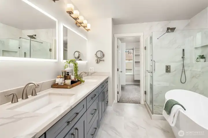 Fully remodeled primary bath with quartz slab, new fixtures, soaking tub, toilet and updated flooring.