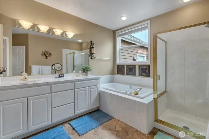 Primary bath with dual sinks, walk-in shower, and soaking tub