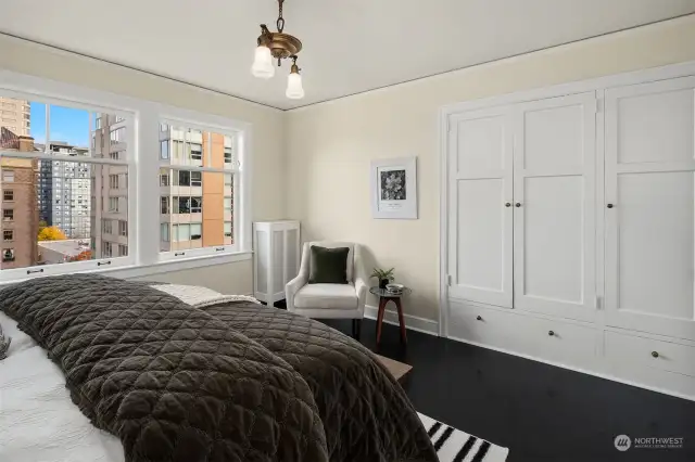 Another angle of this generous bedroom, showing period lighting, urban view and generous built in closet space.