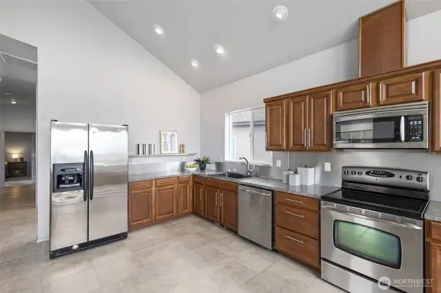 Massive kitchen for entertaining with stainless steel backsplash and lots of storage.
