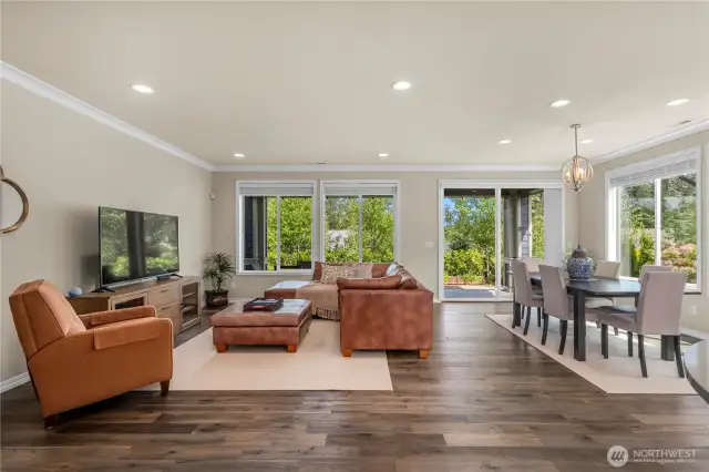 Generous great room and dining area overlooking the beautiful and lush backyard. The Engineered hardwoods are throughout this home.