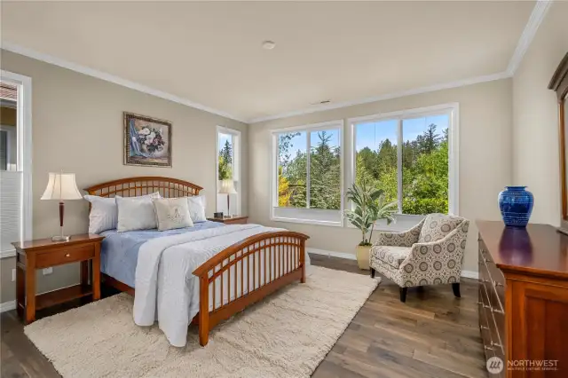 The primary bedroom with Engineered hardwoods, crown molding and top down/bottom up blinds overlooking the scenic and beautiful private backyard.